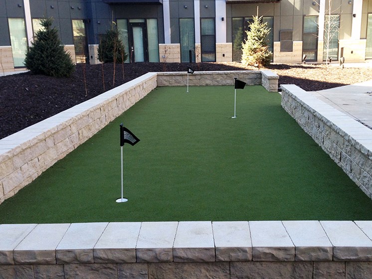 Outdoor putting green with three holes with small flags in them